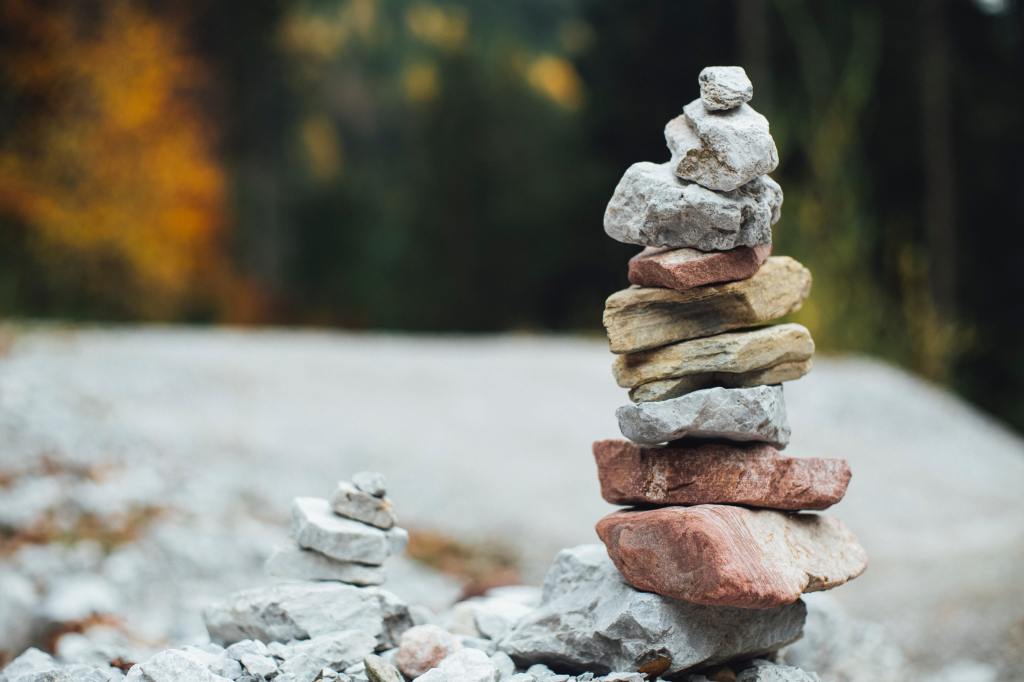 Photograph of a pile of different coloured rocks, balanced one on top of the other.